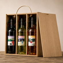 Load image into Gallery viewer, Three wine bottles in a wooden gift box on a wooden surface with a neutral background
